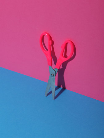 Scissors on a blue pink backgroundの写真素材