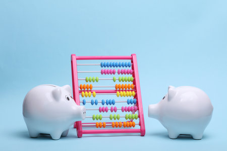 Ceramic white piggy bank with abacus on a blue background. Business concept. Conceptual photoの写真素材