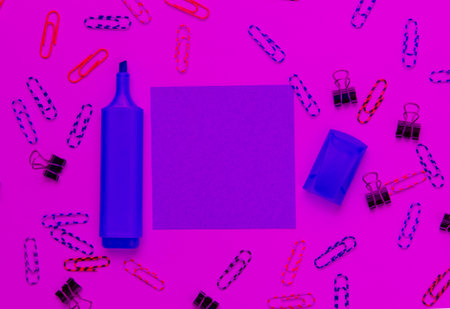 Stationery office supplies. Paper clip, felt-tip pen, memo piece of paper in pink neon lightの写真素材