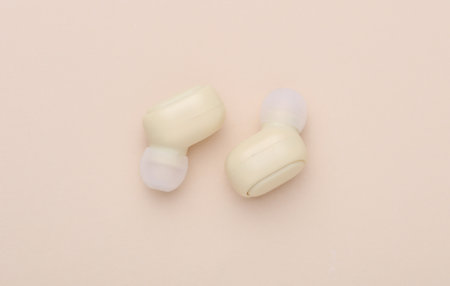 Wireless Earpbuds on a Beige Backgroundの写真素材