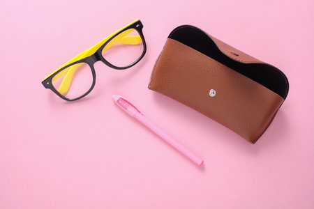 Leather case with eyeglasses on pink backgroundの写真素材