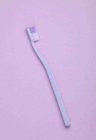 Plastic toothbrush on purple background. Top viewの写真素材