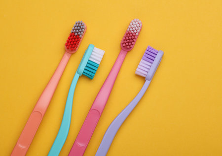 Plastic toothbrushes on a yellow backgroundの写真素材