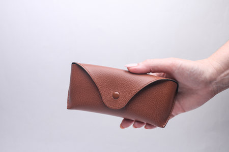 Hand holding Leather case for sunglasses