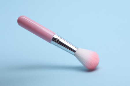 Pink makeup brush on blue backgroundの写真素材