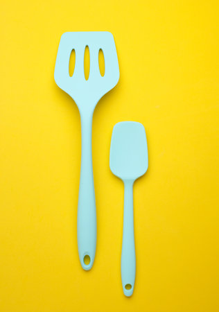 Silicone kitchen spatulas on a yellow backgroundの写真素材