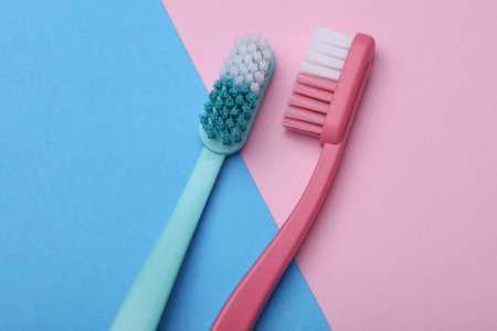 Plastic toothbrushes on blue pink backgroundの写真素材