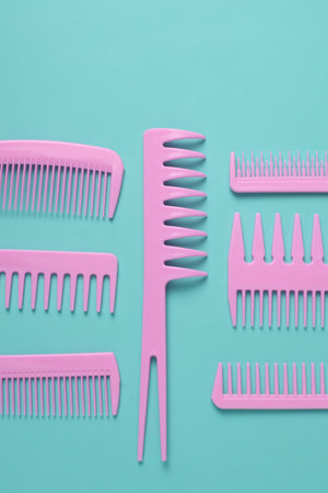 Set of pink plastic combs on mint green background.
