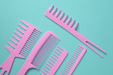 Set of pink plastic combs on mint green background.の写真素材