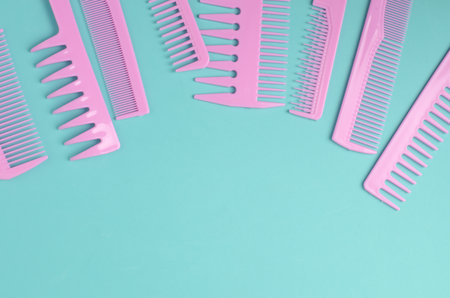 Set of pink plastic combs on mint green background.の写真素材