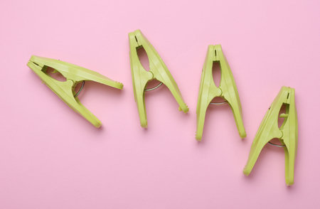 Plastic clothespins on pink background. Top view