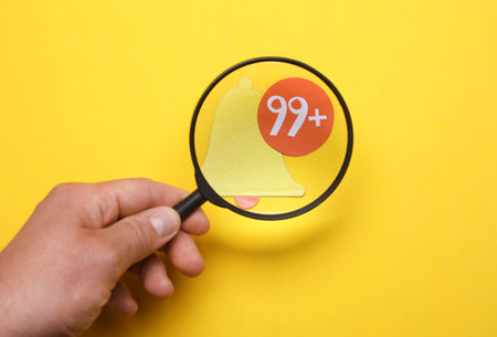 Man looks through a magnifying glass at Notification iconの写真素材