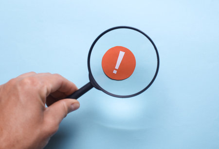 Man looks through a magnifying glass at Notification iconの写真素材