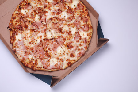 Pizza in a cardboard box on a white backgroundの写真素材