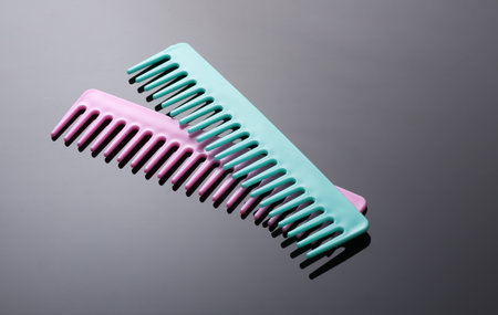 Pink and blue plastic combs on black backgroundの写真素材