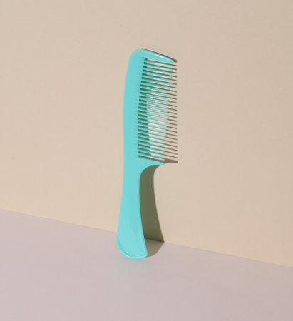 Blue plastic comb on pastel background. Beauty concept. Creative layout. Minimalismの写真素材