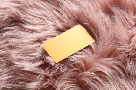 Golden business card on pink fur background.の写真素材