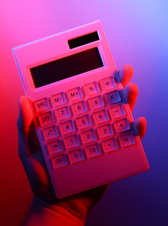 Hand holding calculator in red blue neon lightの写真素材
