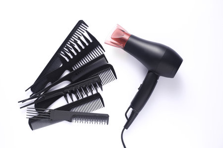 Hair dryer and set of combs on white backgroundの写真素材