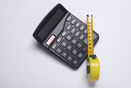Calculator with construction tape measure on white backgroundの写真素材