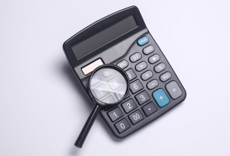 Calculator with magnifying glass on white backgroundの写真素材