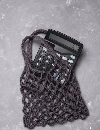 Calculator with string bag on gray concrete backgroundの写真素材