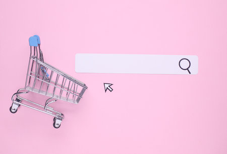 Paper search bar with cursor and shopping trolley on pink background. Online shoppingの写真素材