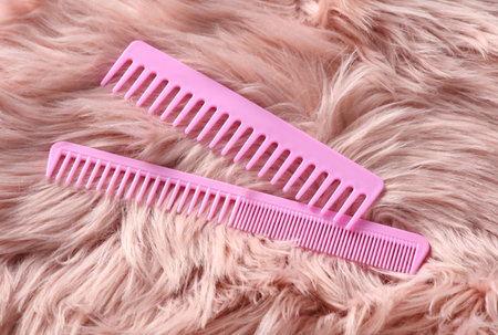 Plastic combs on pink fur background.の写真素材