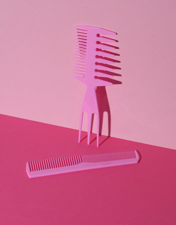 Plastic combs on pink background. Beauty concept. Creative layout. Minimalism