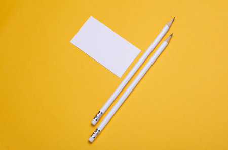 Pencils with business card on yellow backgroundの写真素材