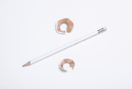 White sharpened pencil and shavings on white background
