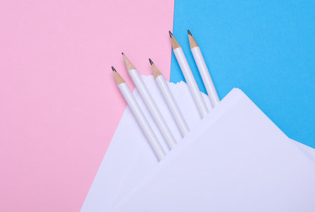 Pencils with white blank sheets of paper on blue pink backgroundの写真素材