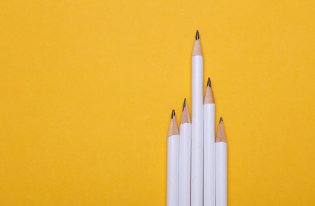 White wooden pencils on yellow background. Mockup for designの写真素材