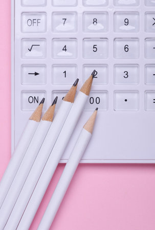 Calculator with pencils on pink backgroundの写真素材