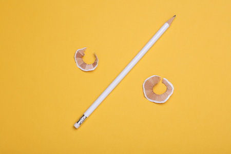 White sharpened pencil with sharpener on yellow backgroundの写真素材