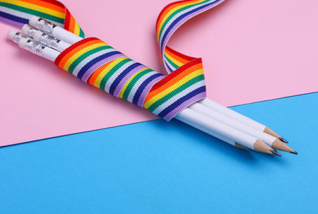 Pencils wrapped with lgbt rainbow tape on blue pink backgroundの写真素材