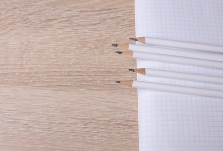 Pencils with notebook on wooden tableの写真素材