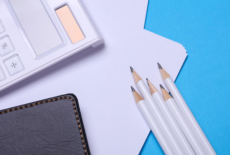 Workspace with pencils, sheets of paper and a calculator. Flat lay