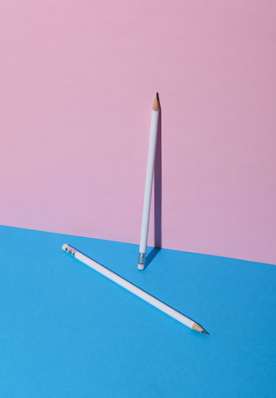 White wooden pencil with eraser on pink blue background. Creative layout