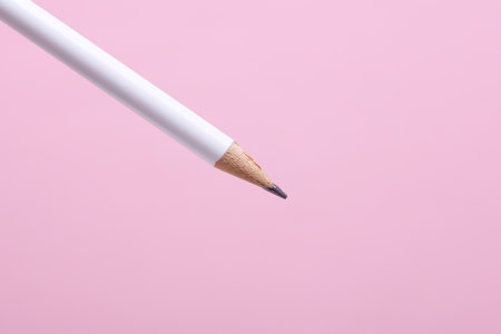 White wooden pencil on pink backgroundの写真素材