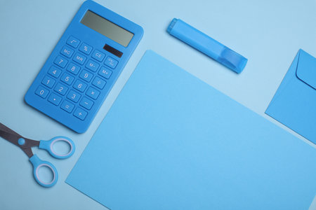 Blue sheets of paper with school stationery on blue background. Monochrome photography. Flat lay. Creative layoutの写真素材
