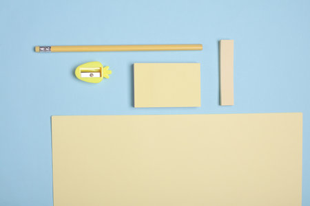 Yellow sheets of paper and school stationery on a blue background. Creative layoutの写真素材