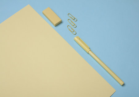 Yellow sheets of paper and school stationery on a blue background. Creative layout