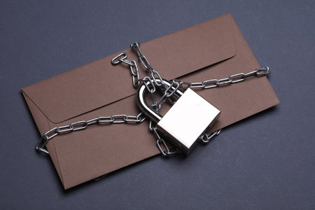 Envelope wrapped in steel chain and lock. Secret informationの写真素材