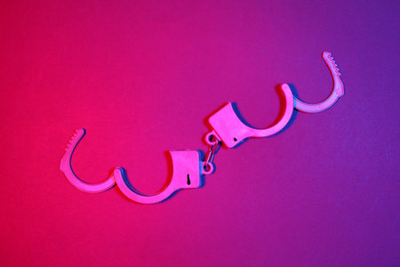 Plastic toy handcuffs in blue red neon lightの写真素材
