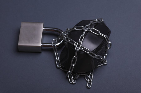 PC mouse wrapped in steel chain with lock on dark backgroundの写真素材