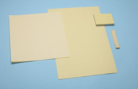 Yellow sheets of paper and note stickers on a blue background
