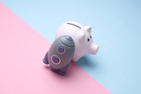 Piggy bank and space shuttle on blue pink background. Startup ideaの写真素材