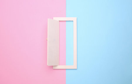 Miniature open wooden door on blue pink backgroundの写真素材