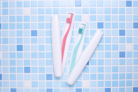 Plastic cases with toothbrushes on tile backgroundの写真素材